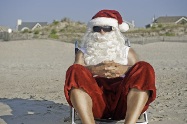 Christmas in July: Santa Claus on vacation relaxing at the beach