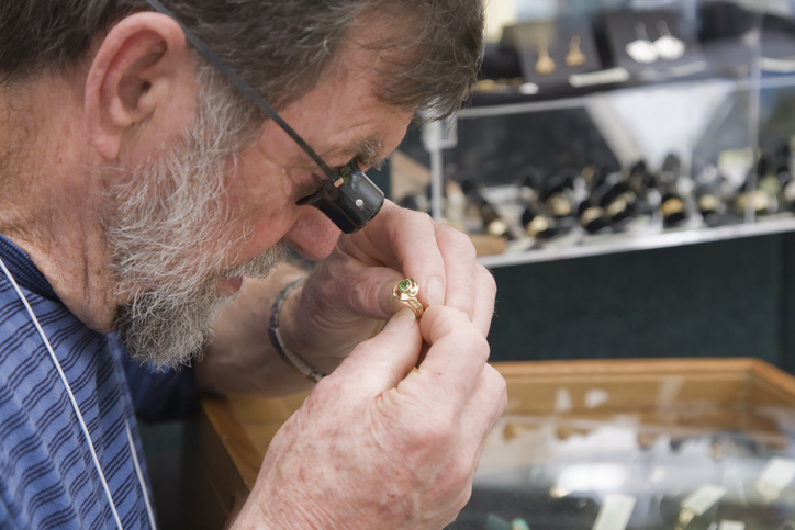 History of pawn shops: A man appraising jewelry.