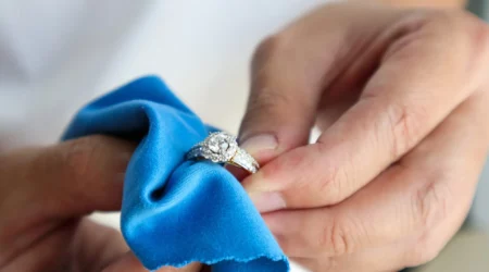 Jeweller hand polishing and cleaning jewelry diamond ring with micro fiber fabric