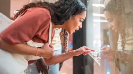 Diverse couple enjoys a relaxed window shopping experience at a jewelry store, adding a touch of leisure to their day.