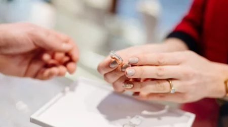 Female seller in a luxury jewelry store presents a ring. Buying a engagement ring. Jewelry store. Woman jeweler.