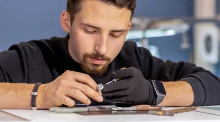 A jeweler in the workshop working on a ring with zircona. Ring in the hands of the jeweler close-up