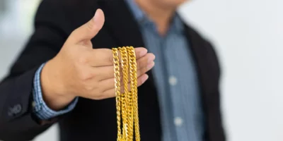 Wealthy businessman holding a golden necklace.