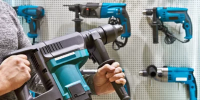 Hammer drill in man's hands closeup