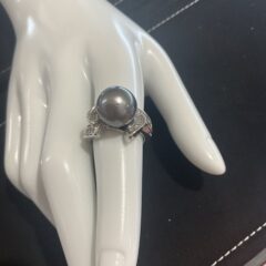 Elevate your style with this women’s fashion ring, showcasing sparkling diamonds and a lustrous black pearl. Its elegant design makes it a stunning statement piece for any occasion.